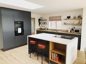 Modern Kitchen painted in grey with oak interiors and waterfall island quartz